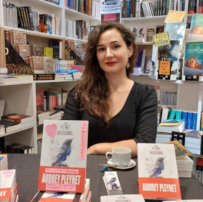 Portrait de Audrey Pleynet, marraine 2025, avec ses livres devant elle.